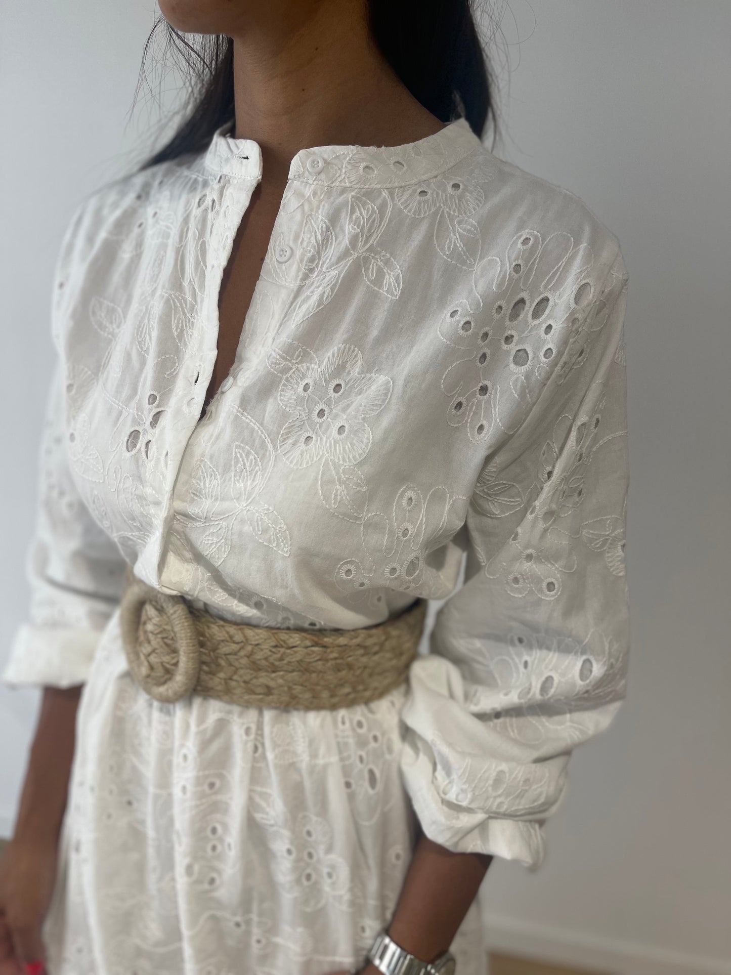 Gros plan sur la broderie ajourée de la robe maxi blanche