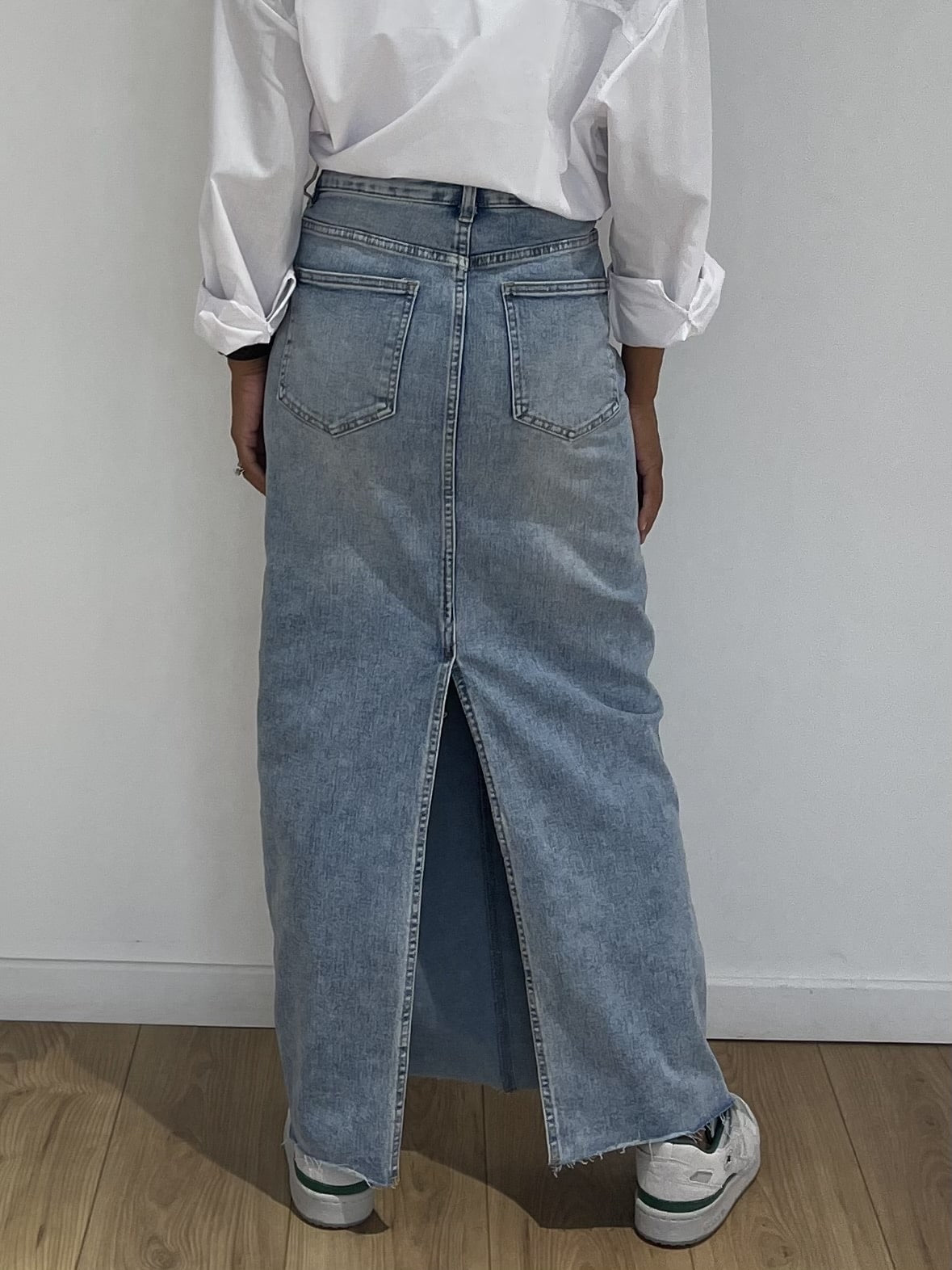 Détail de la jupe longue en jean bleu avec coutures contrastantes