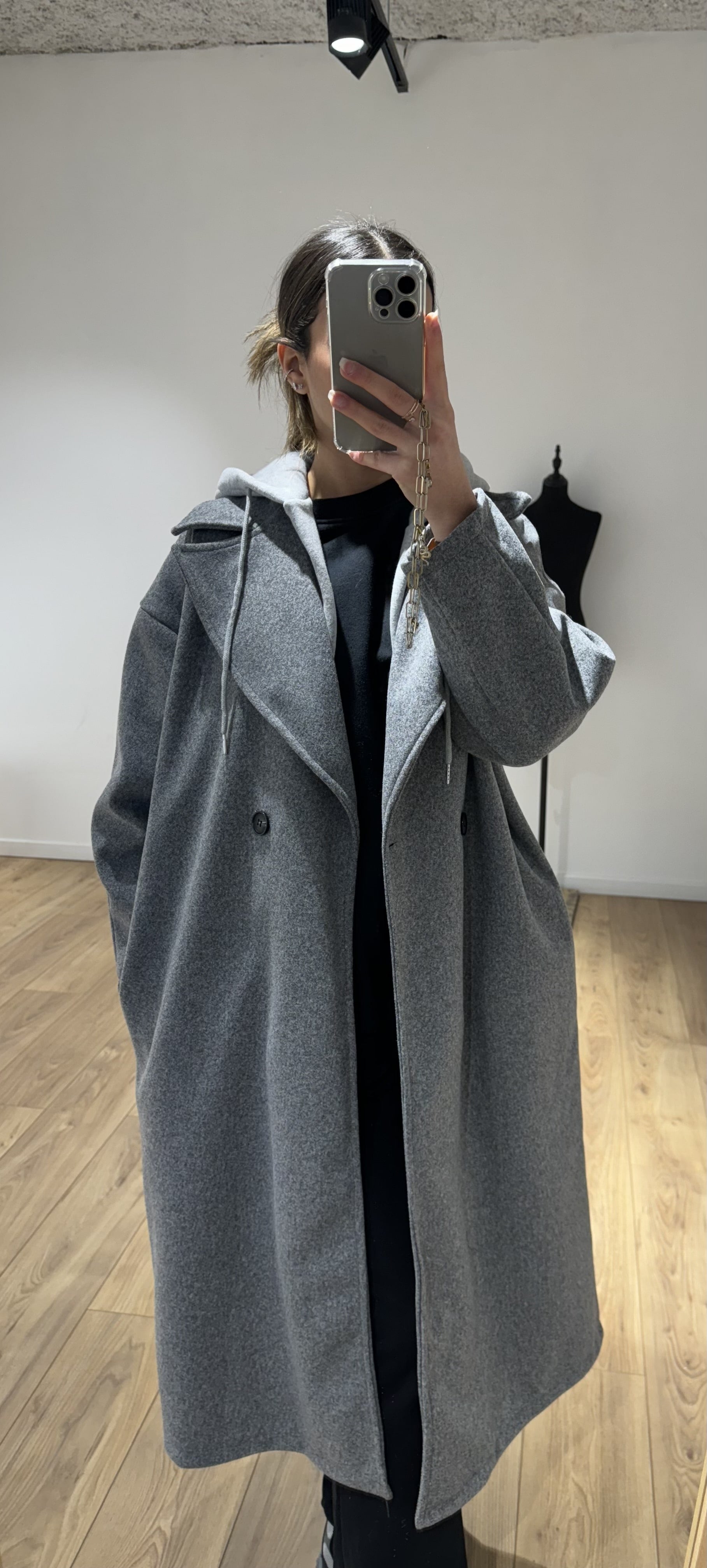 Manteau chic gris avec capuche, essentiel de l'hiver 2024 pour un look affirmé.