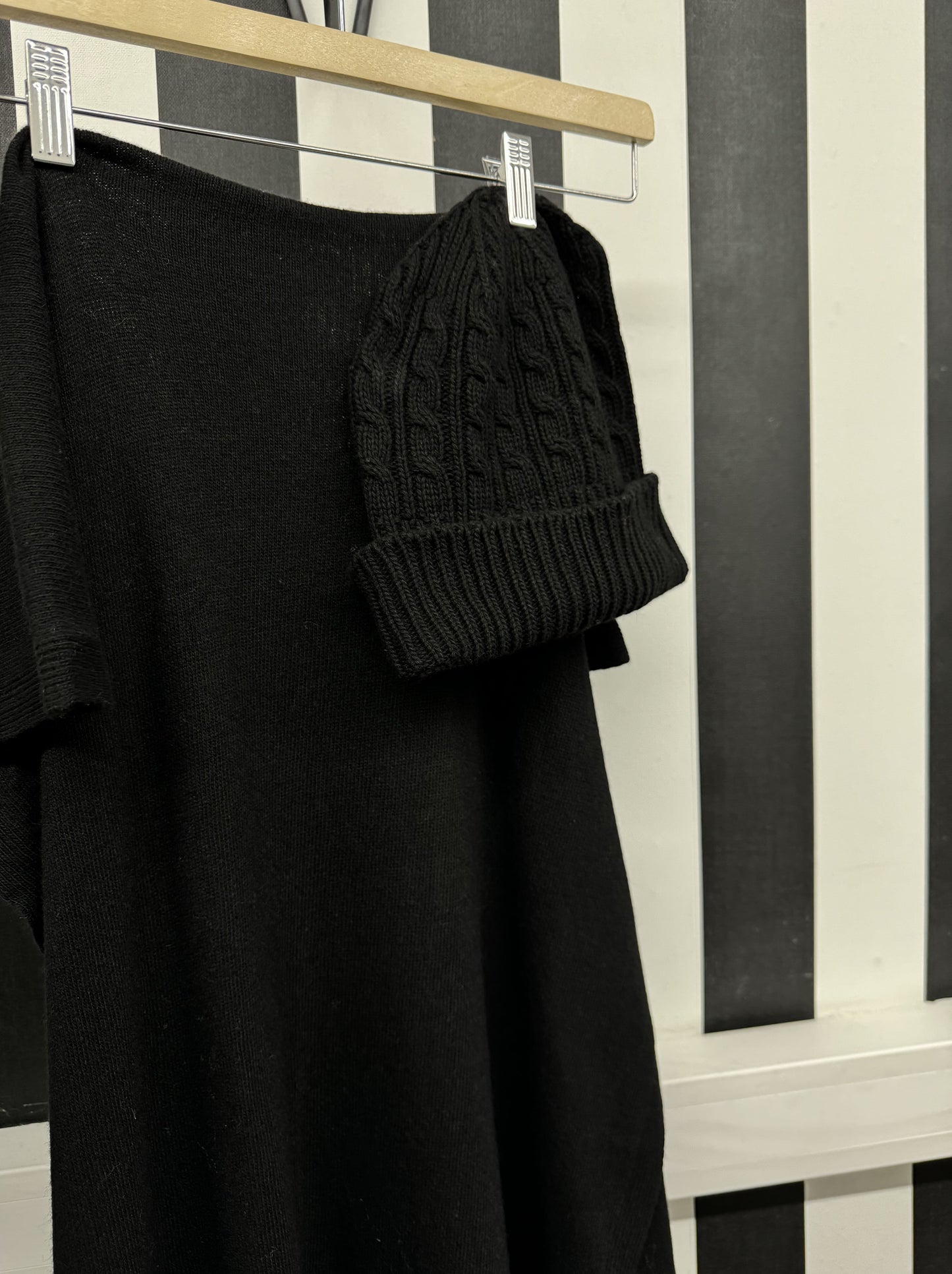 Bonnet en cachemire noir sur cintre contre rayures