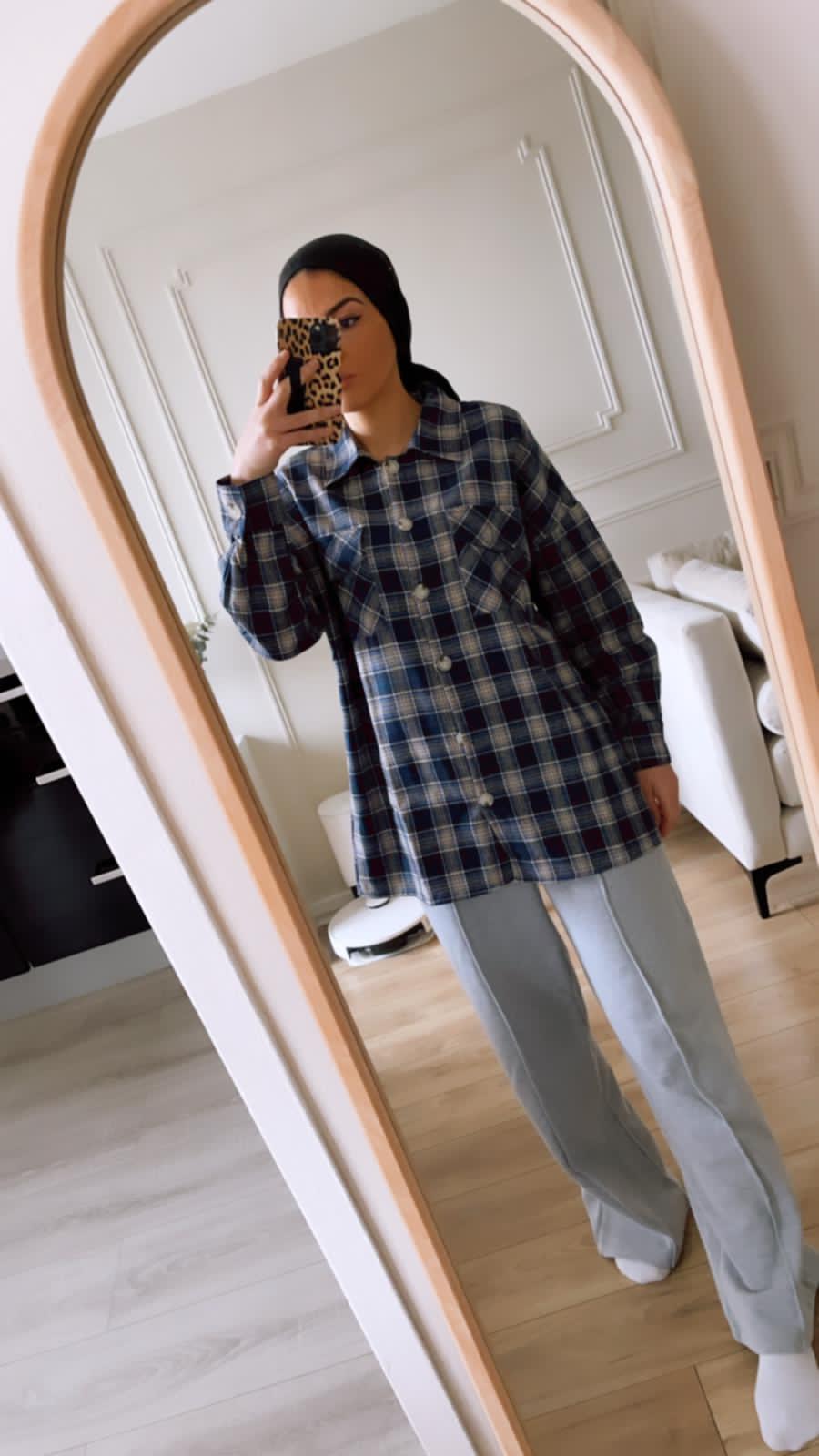 Femme portant une chemise à carreaux bleu devant un miroir