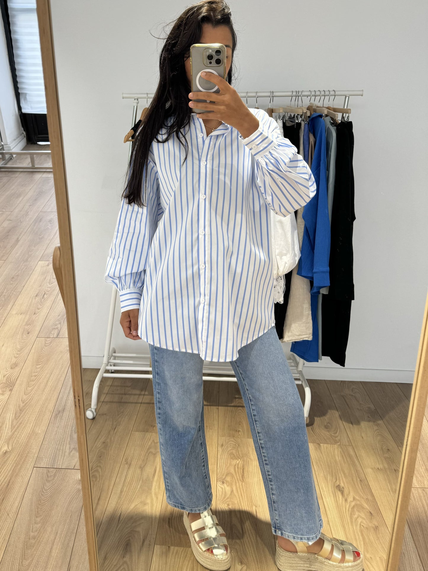 Chemise rayée bleu pour femme, vue dans le miroir, portée avec un jean.