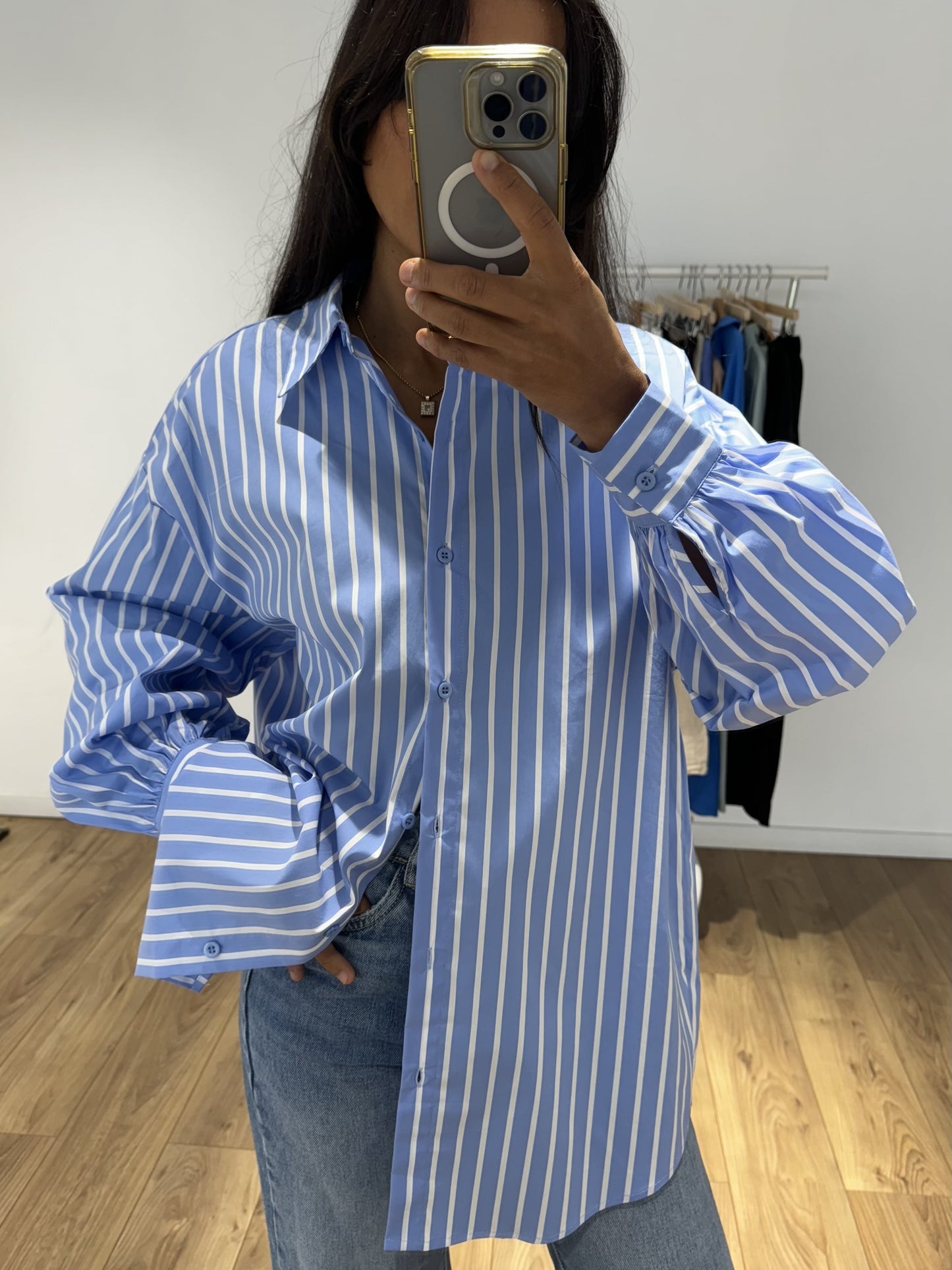 Détail de la chemise rayée bleu pour femme, manches longues et boutons.