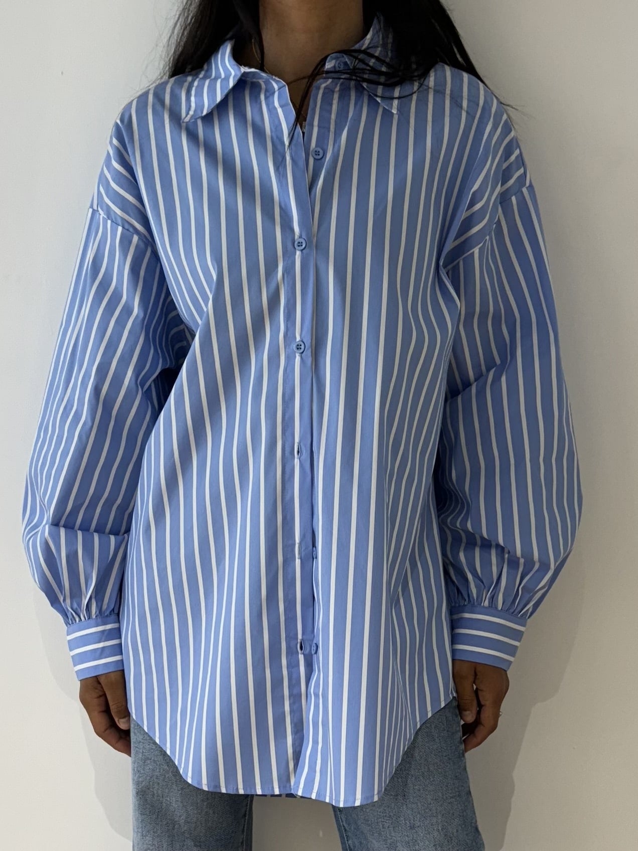 Chemise rayée bleu pour femme, vue de face, portée avec un jean.