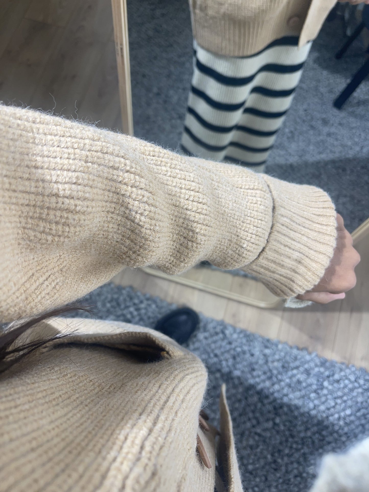 Détail de manche de gilet beige en tricot côtelé