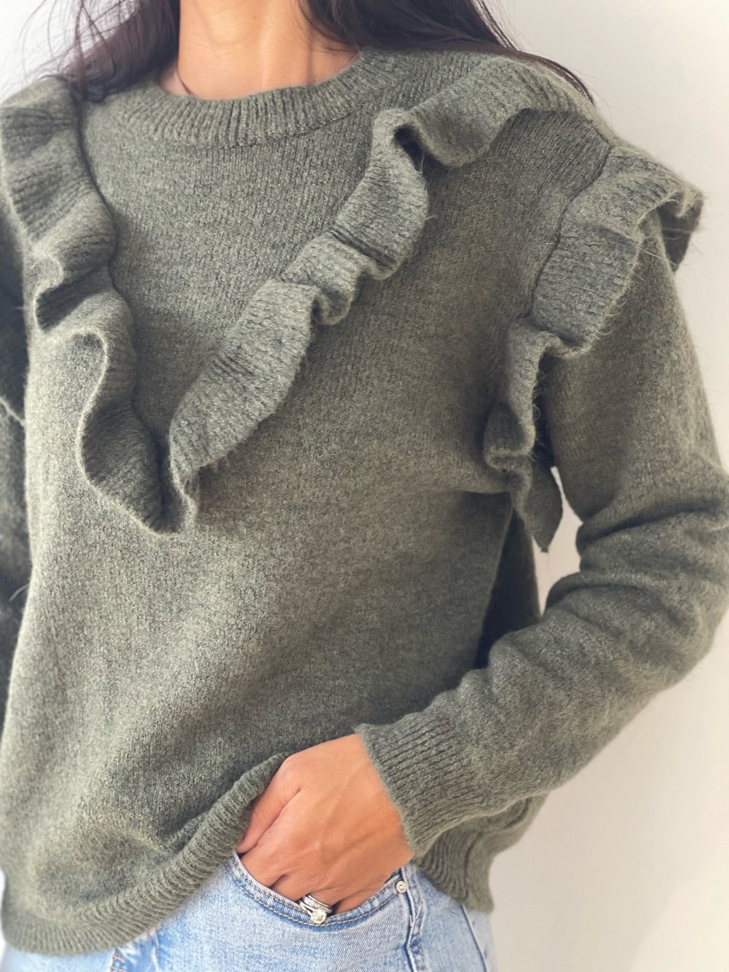 Gros plan du pull froufrou vert mettant en valeur la texture de la maille
