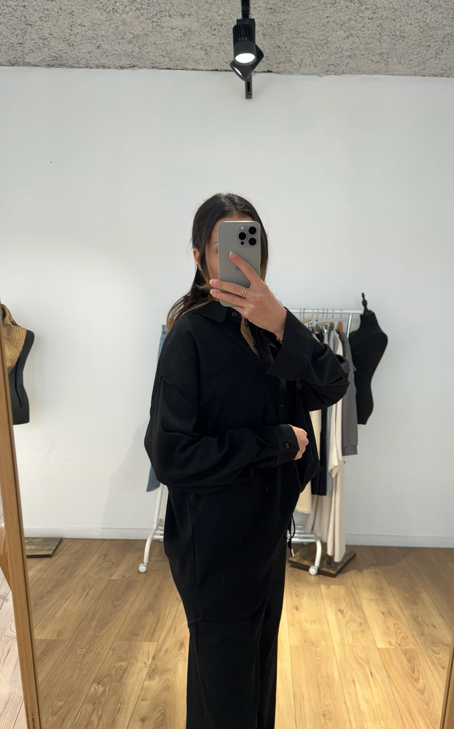 Femme portant un ensemble chemise et pantalon noir, vue de profil