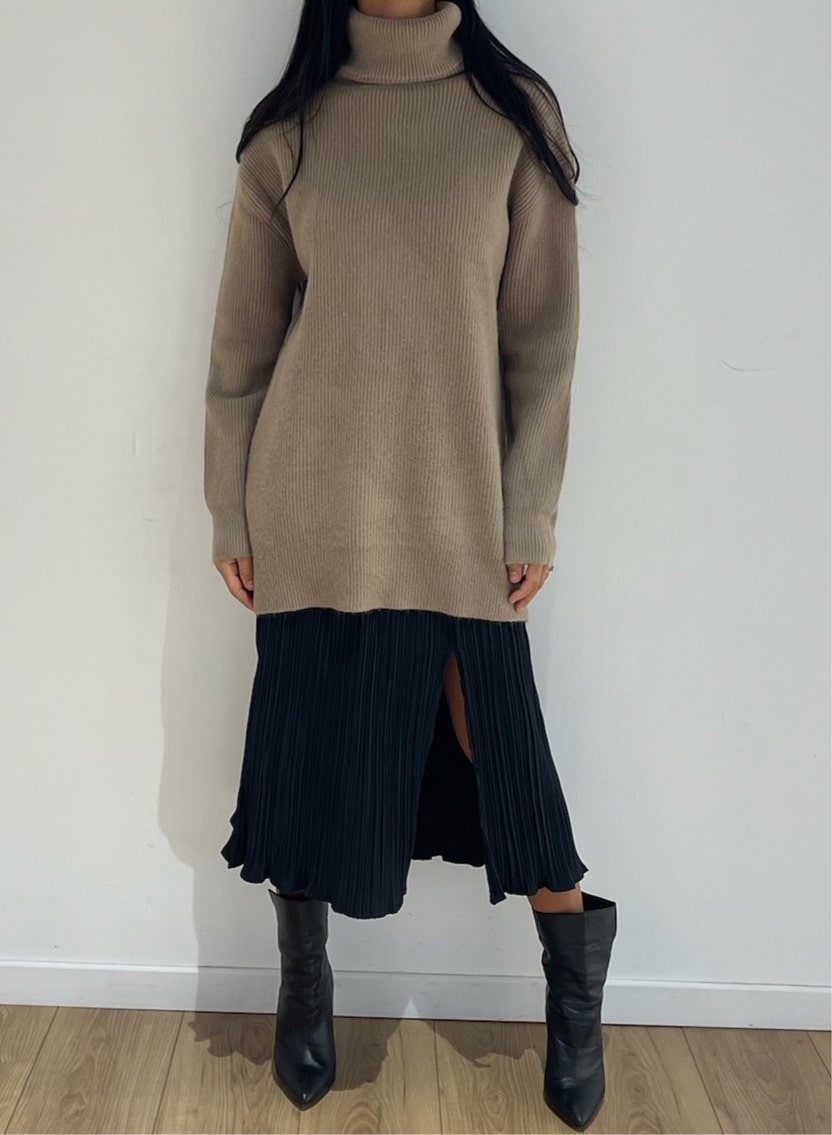 Col roulé long taupe en maille côtelée associé à une jupe plissée noire