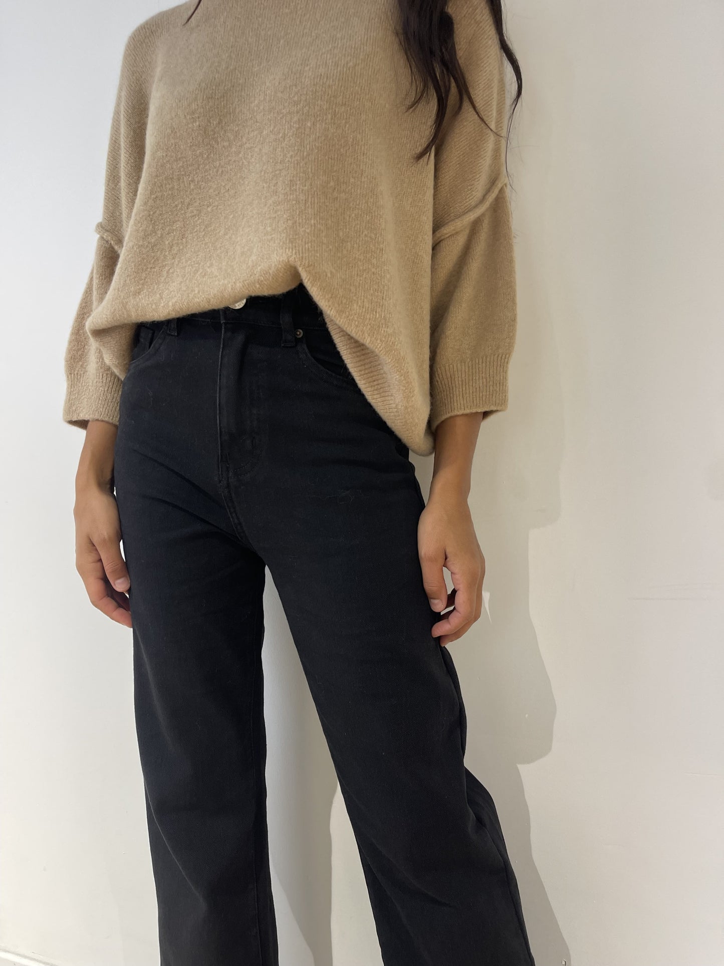 Zoom sur le jean noir coupe droite pour femme, détails de la taille haute et coupe classique.