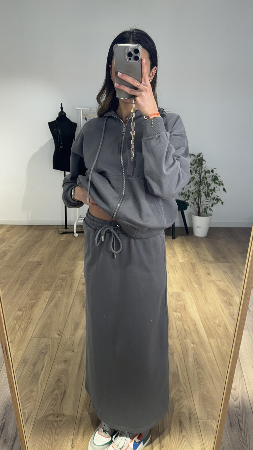 Femme portant une jupe longue en coton gris avec fermeture éclair et cordon de serrage