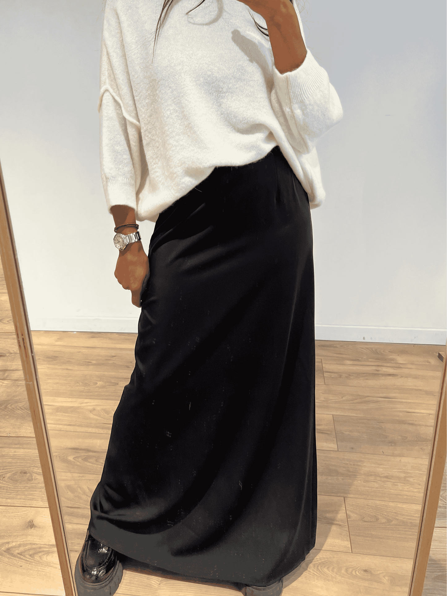 Femme portant une jupe longue en satin noir, vue de côté