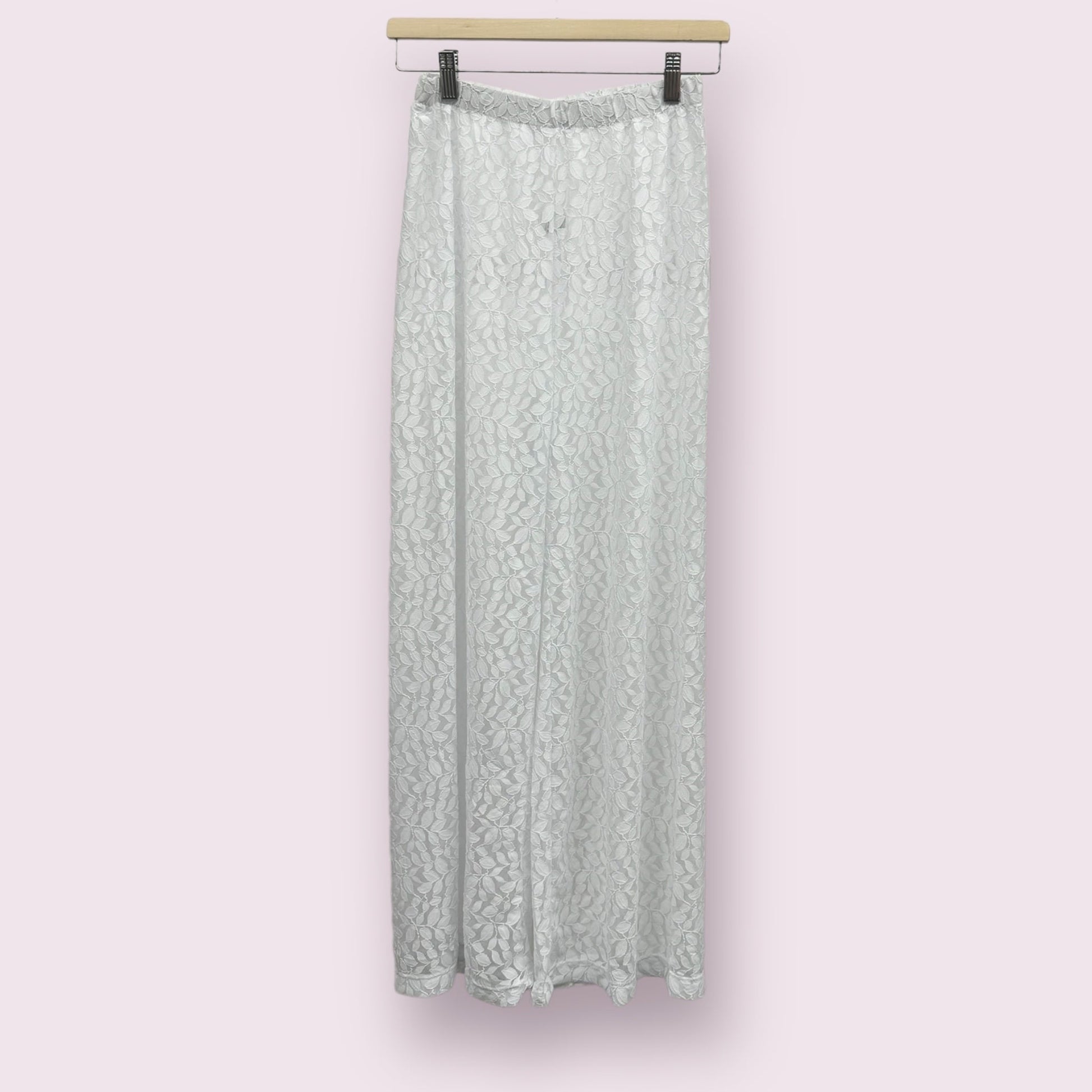 Pantalon de plage pour femme en blanc, sur un cintre.