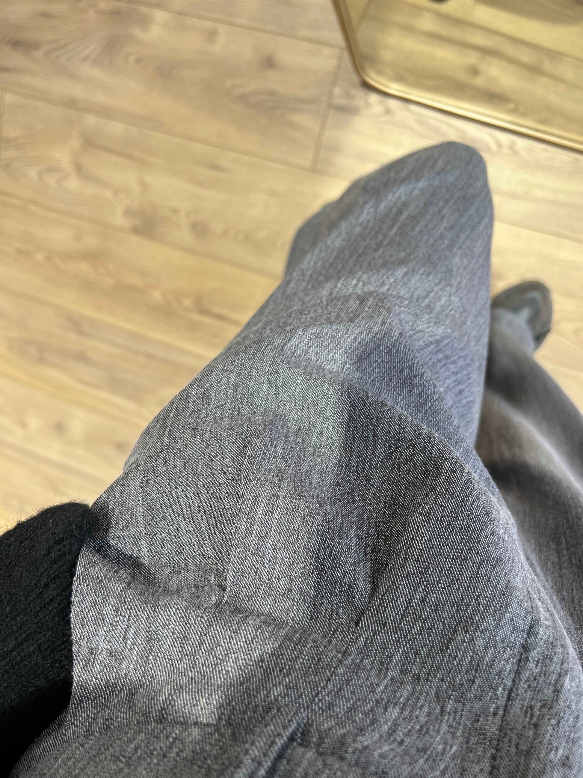 Zoom sur la texture du tissu d'un pantalon gris ample pour femme.