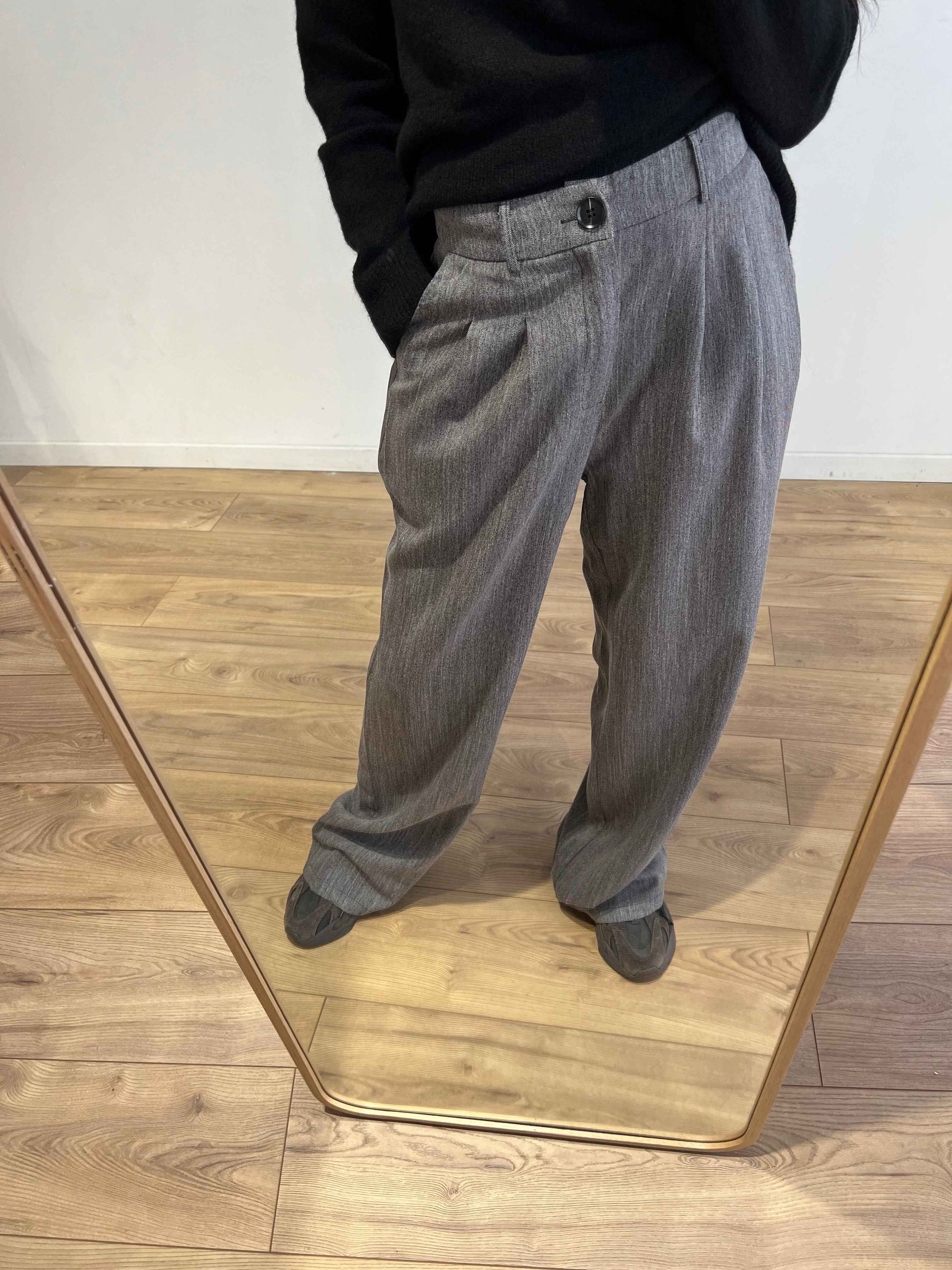 Zoom sur le pantalon gris ample pour femme, vue en miroir.