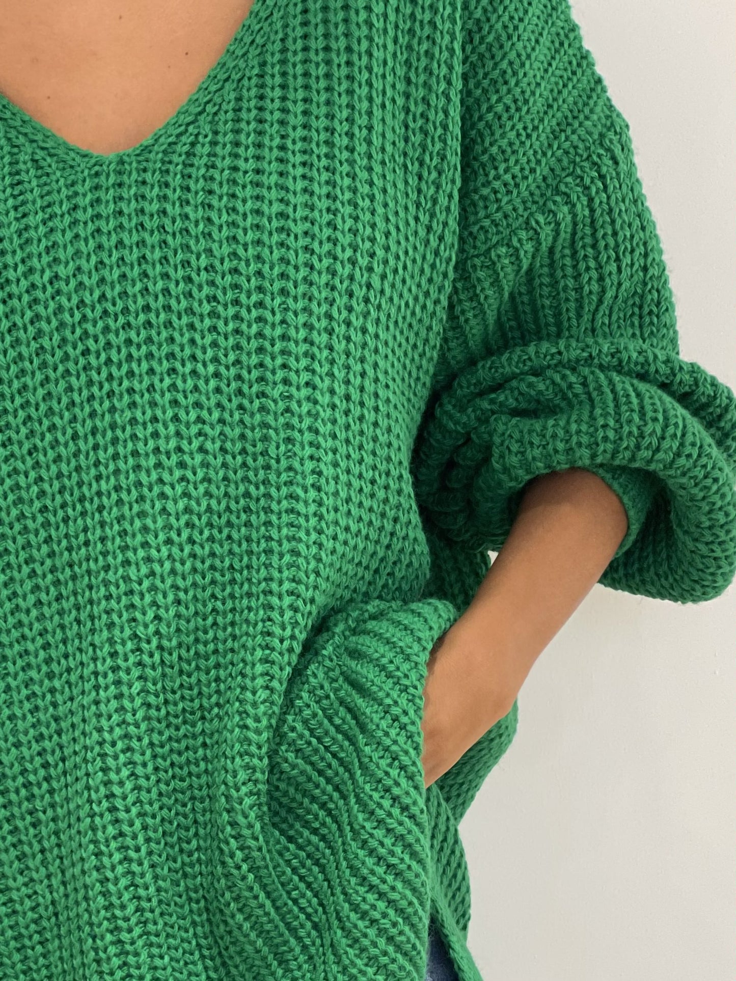 Gros plan sur la texture de la maille épaisse du pull vert