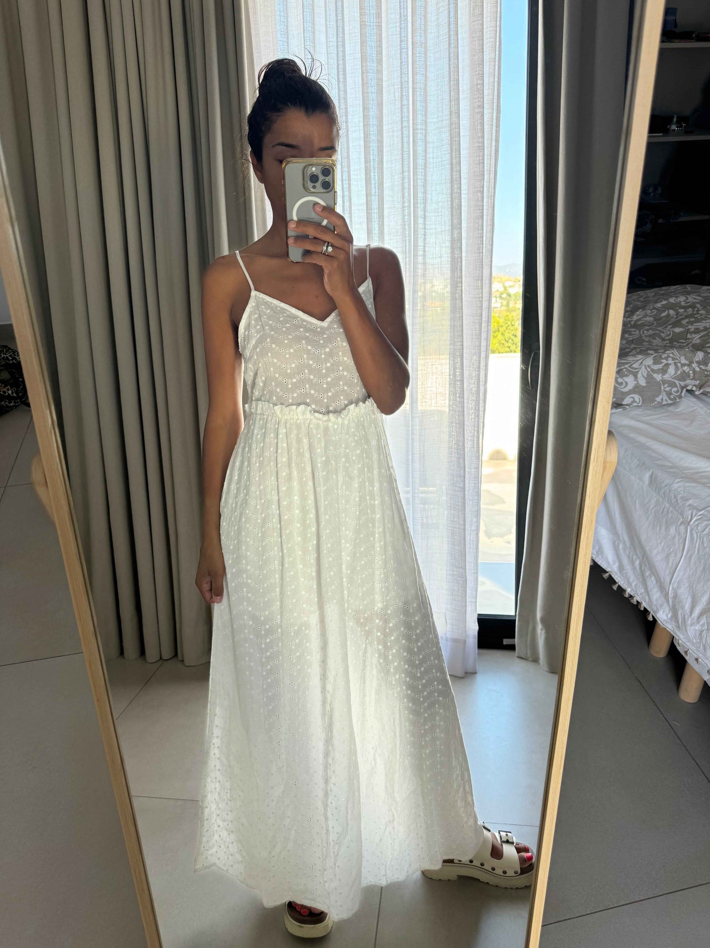 Femme portant une robe blanche longue à fines bretelles, style bohème, vue de face