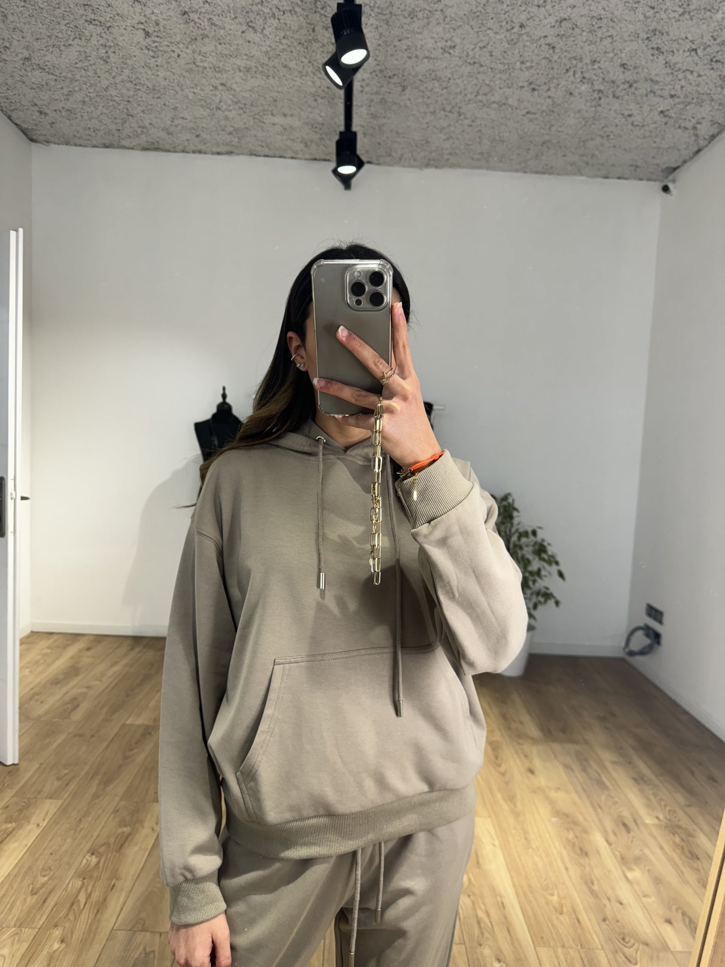 Jeune femme portant un sweat à capuche beige dans un intérieur moderne