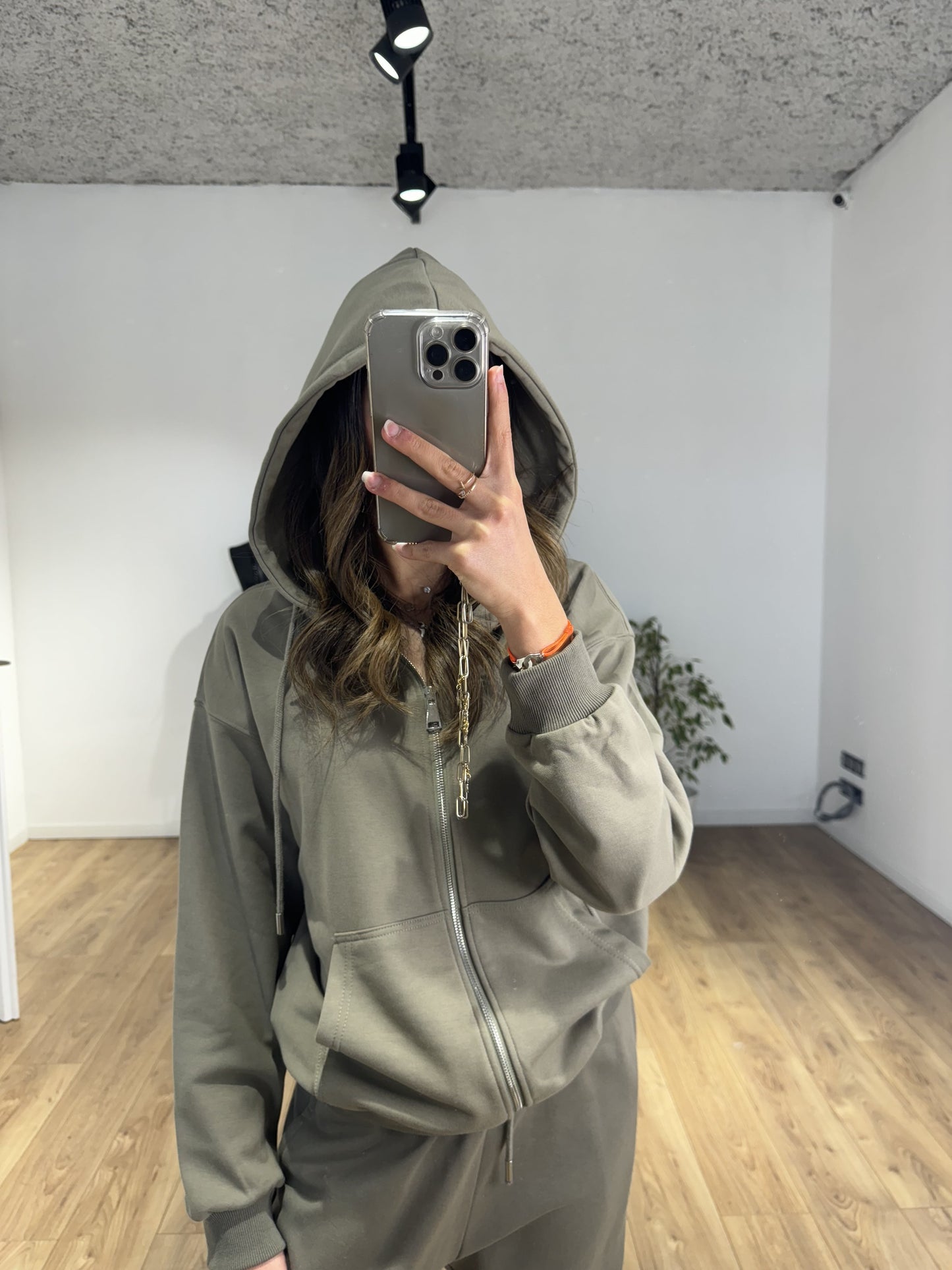 Femme avec capuche levée sur sweat à capuche zippé gris