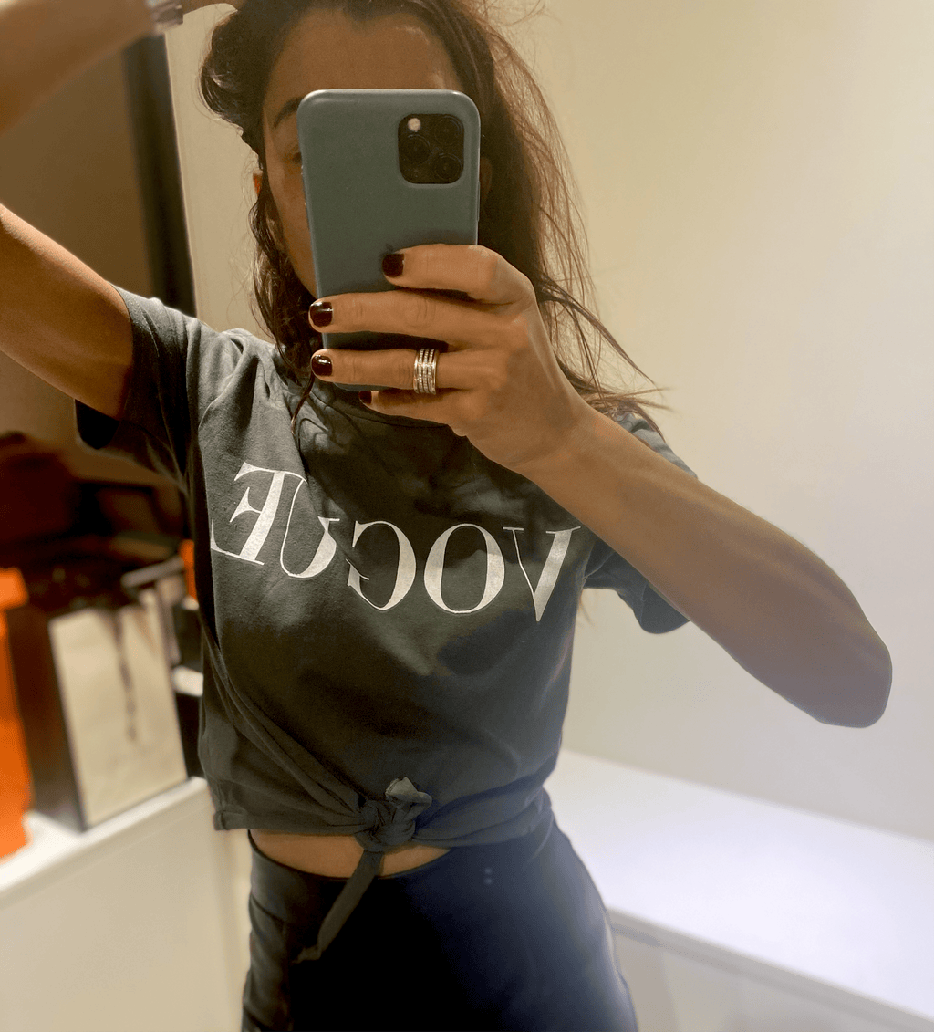 femme portant un t-shirt kaki avec logo blanc, vue en miroir