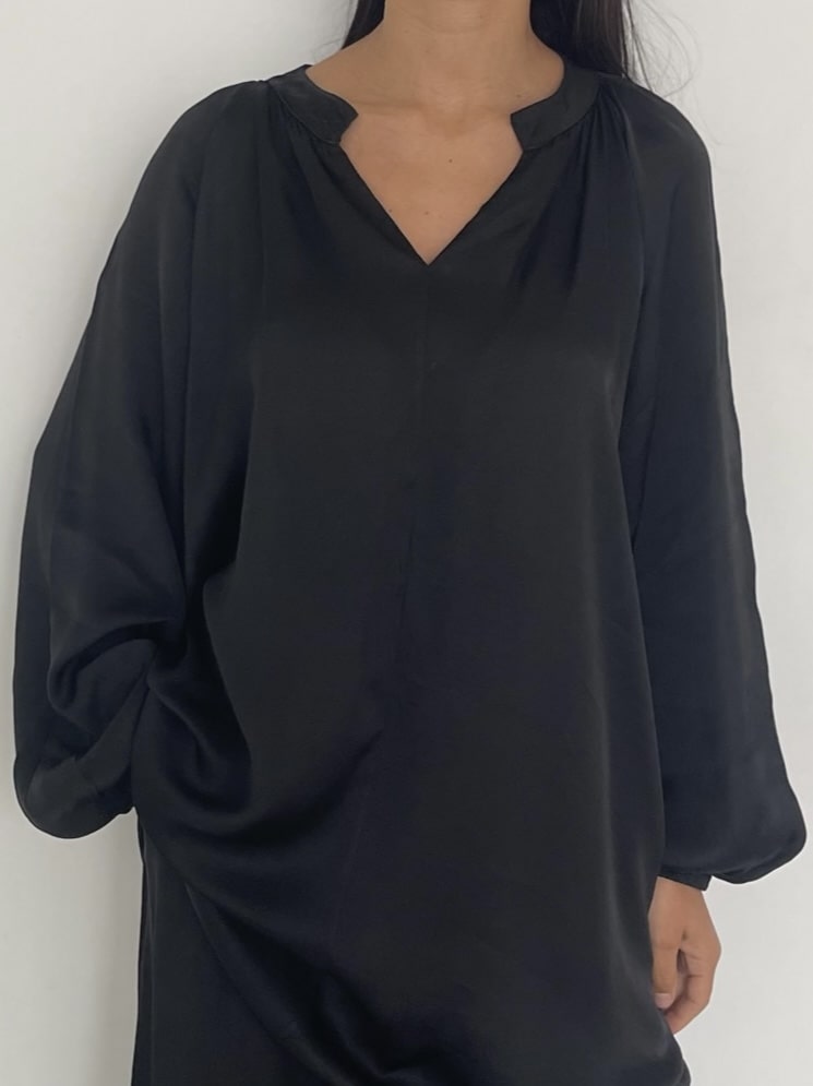 Zoom sur tunique noire de l'ensemble Damas, élégance décontractée en soie
