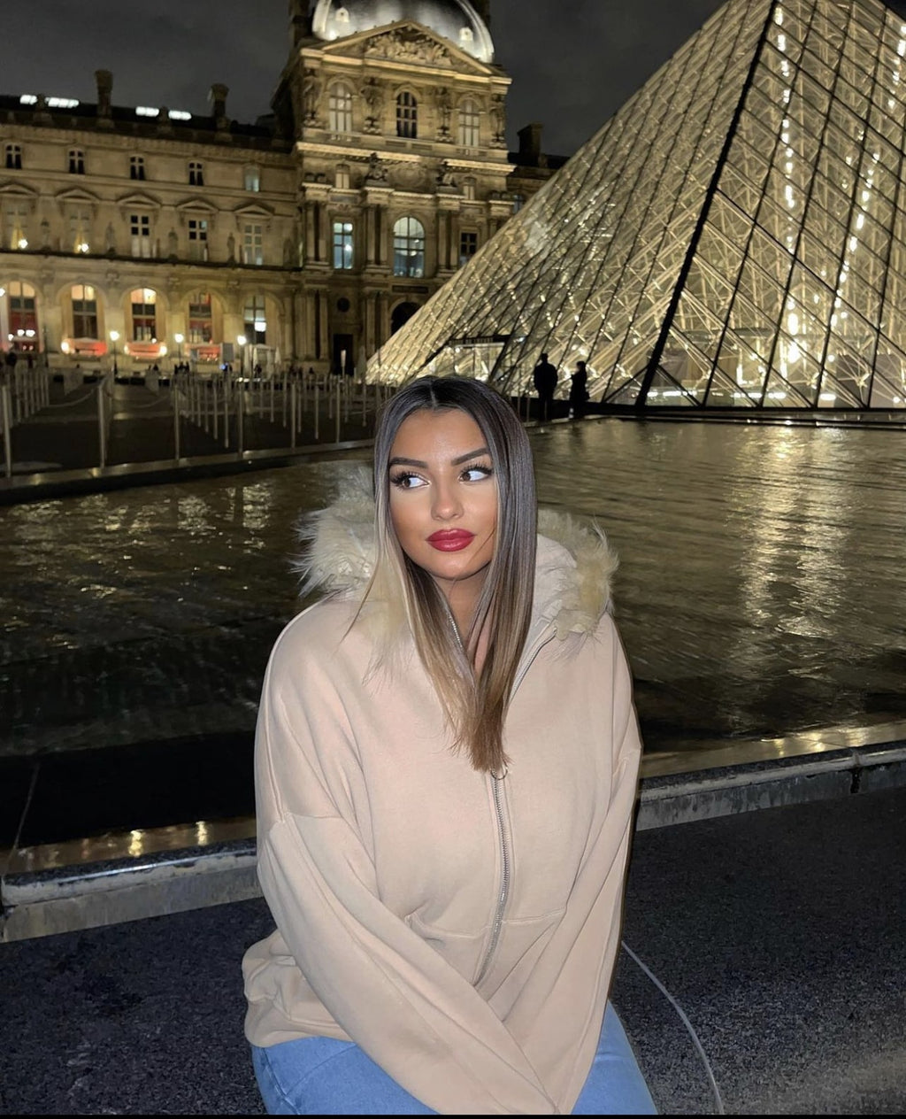 Femme à Paris portant une veste à capuche beige avec fourrure synthétique