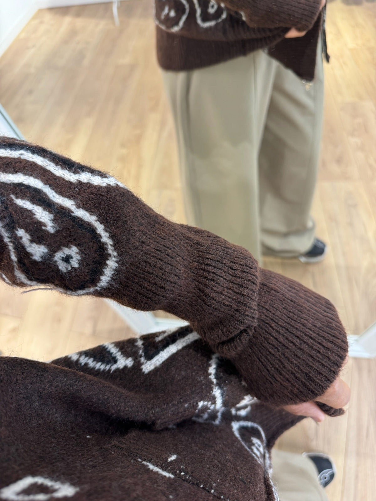 Détail du motif jacquard écru du gilet marron