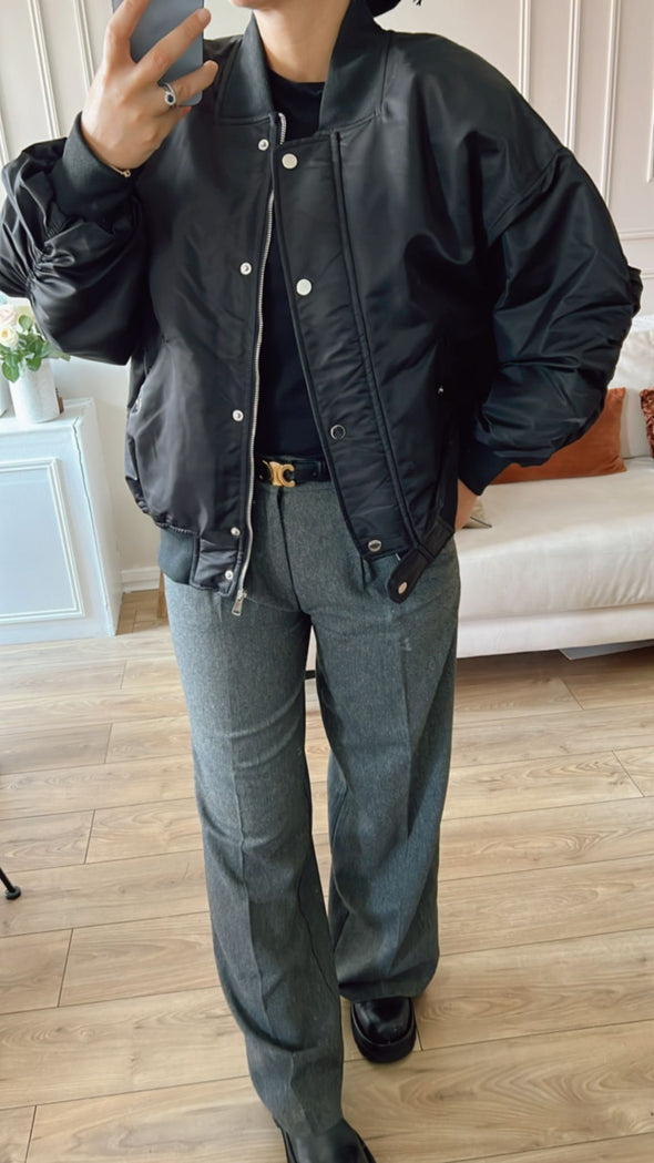 Bomber noir élégant parisien stylé avec un pantalon classique gris pour une déclaration de mode intemporelle