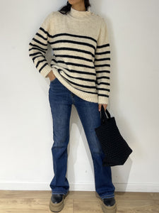 Jeans bleus coupe droite classique avec pull rayé et chaussures à plateforme pour un style décontracté tendance.