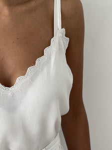 Gros plan sur jupe longue blanche avec motifs ajourés et tissu léger