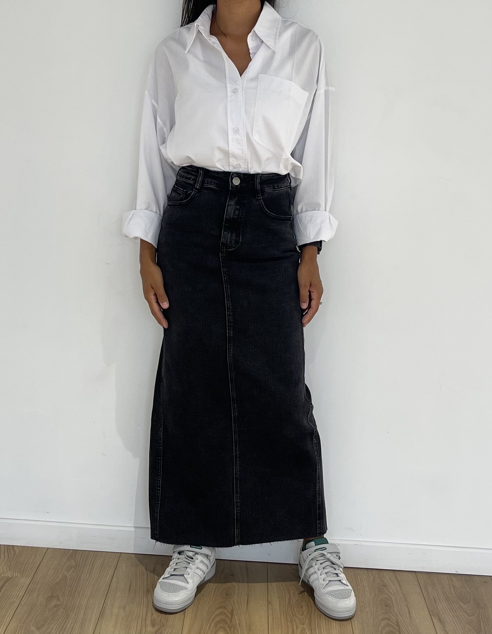 Apparence tendance avec jupe longue en jean noire et tennis blanches