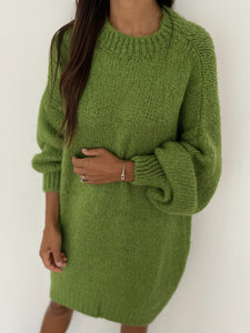 Gros plan sur une robe-pull tricotée en vert avec une texture douce.