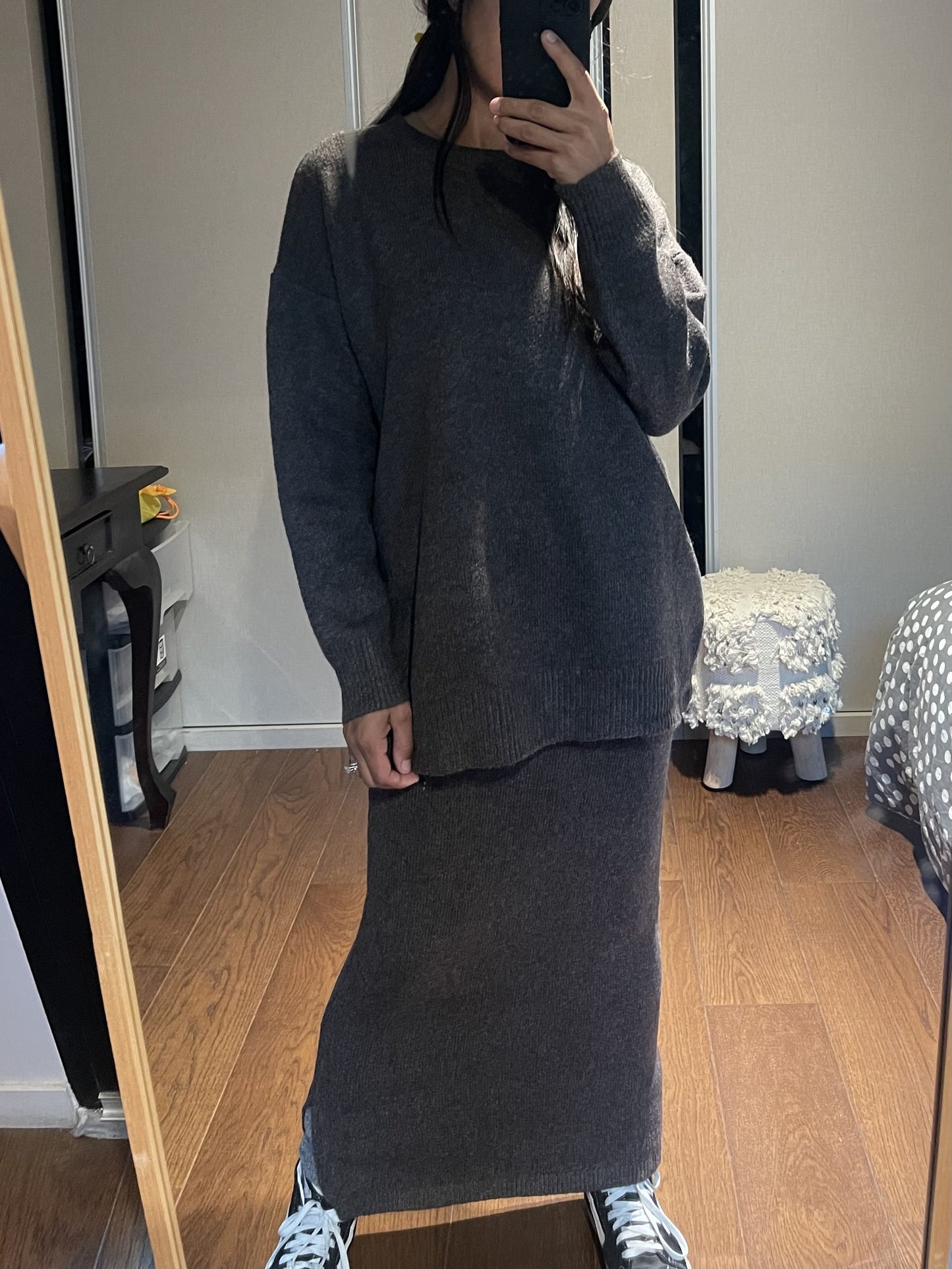 Femme portant une robe-pull marron devant un miroir