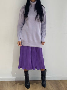 Col roulé parme en maille côtelée assorti à une jupe plissée violette et des bottes noires
