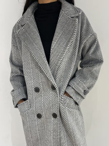 Zoom sur les détails d'un manteau long à chevrons, pour une touche d'originalité.