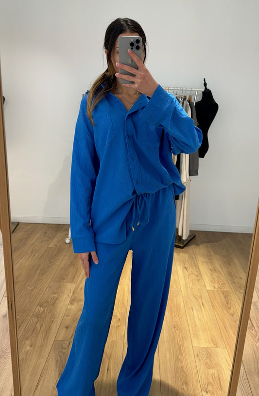 Femme portant un ensemble chemise et pantalon bleu, vue de face