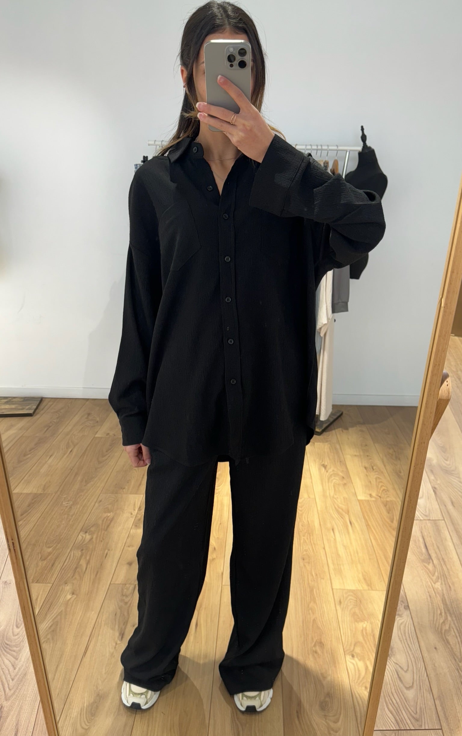Femme portant un ensemble chemise et pantalon noir, vue de face