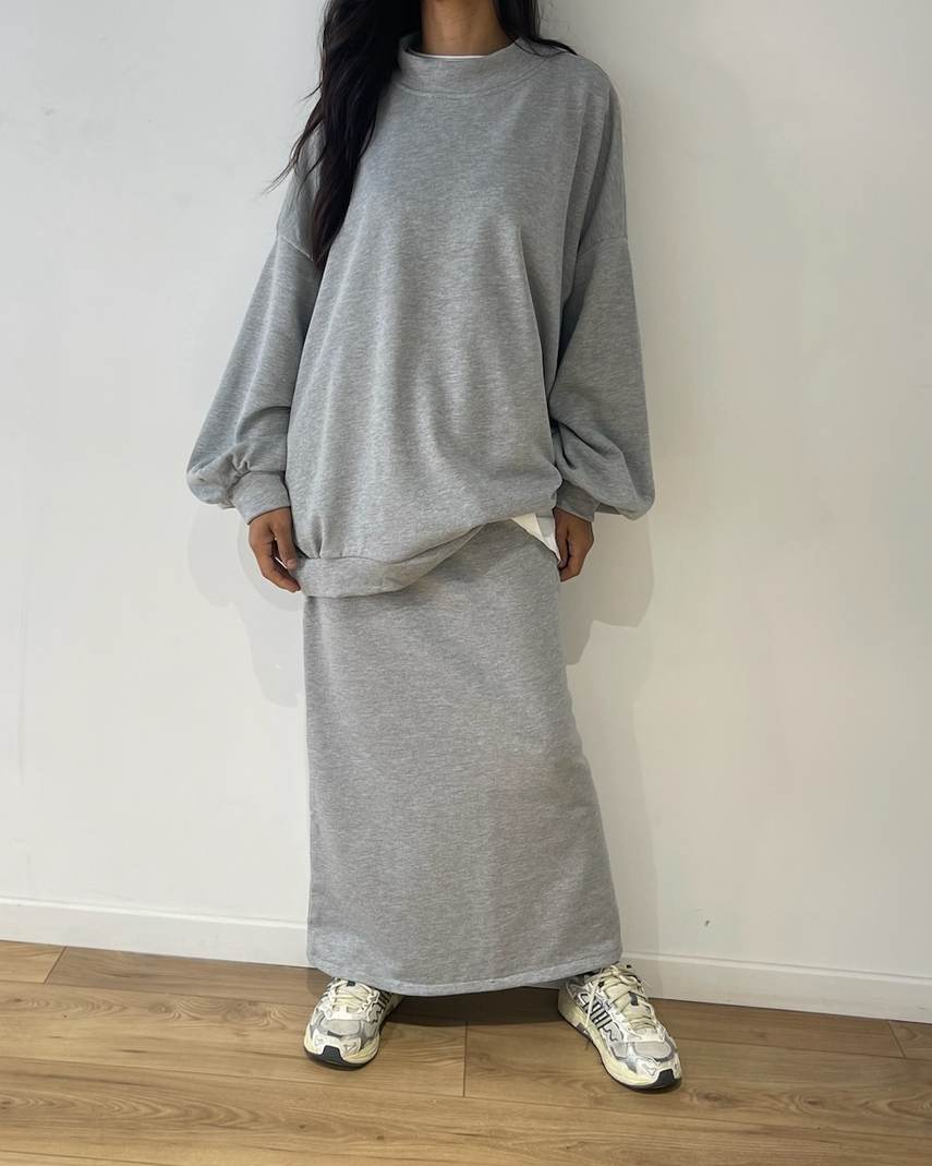 Femme portant un ensemble pull et jupe longue en gris 100% coton