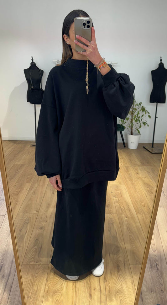 Ensemble jupe et pull noir porté avec des baskets blanches 100% coton