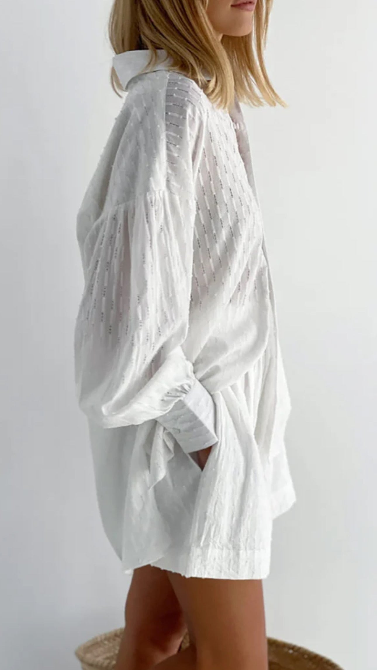 Vue de côté de l'ensemble chemise et short blanc pour femme, manches bouffantes.