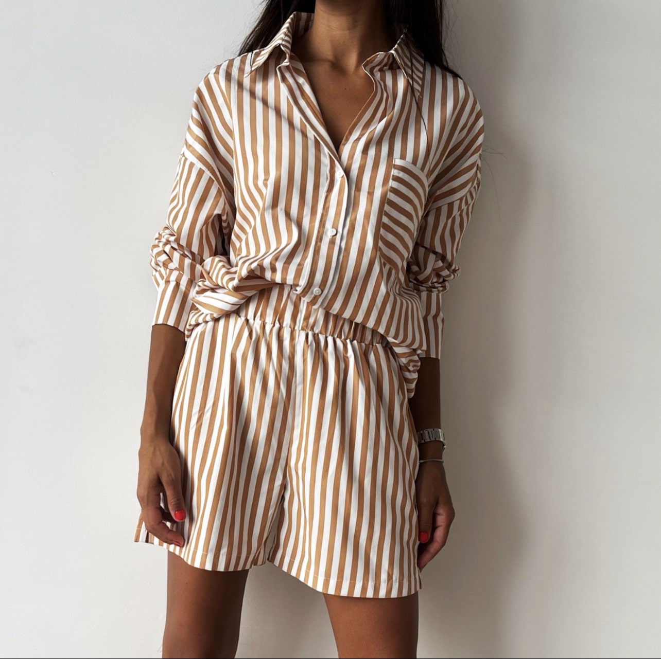 Look estival avec ensemble marinière beige et blanc, short et chemise ample pour femme.