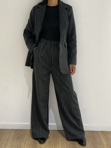 Femme portant un ensemble pantalon rayé et veste assortie