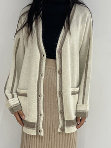 Gilet en laine écru à rayures taupe, boutonnage avant et manches longues, alliant confort et sophistication.