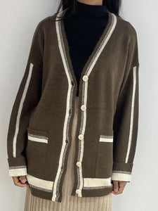 Gilet fin en laine marron avec rayures blanches et boutons contrastants, parfait pour un look décontracté.