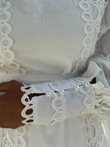 Détails de manche perlé sur robe longue en dentelle blanche