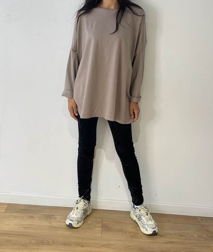 Haut oversize taupe porté de manière décontractée par une femme