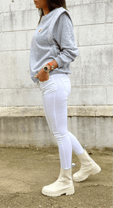 Profil de jean blanc slim pour femme avec top gris et bottes montantes