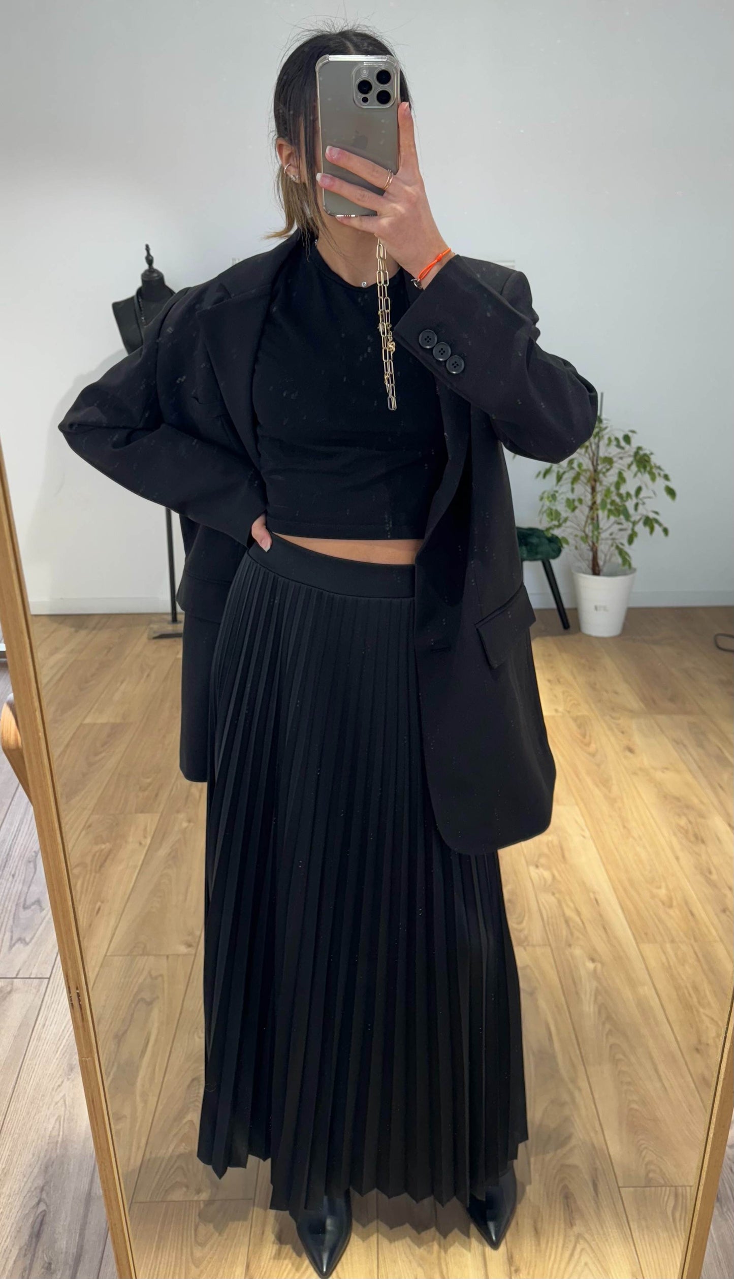 Femme portant une jupe longue plissée noir et haut sombre