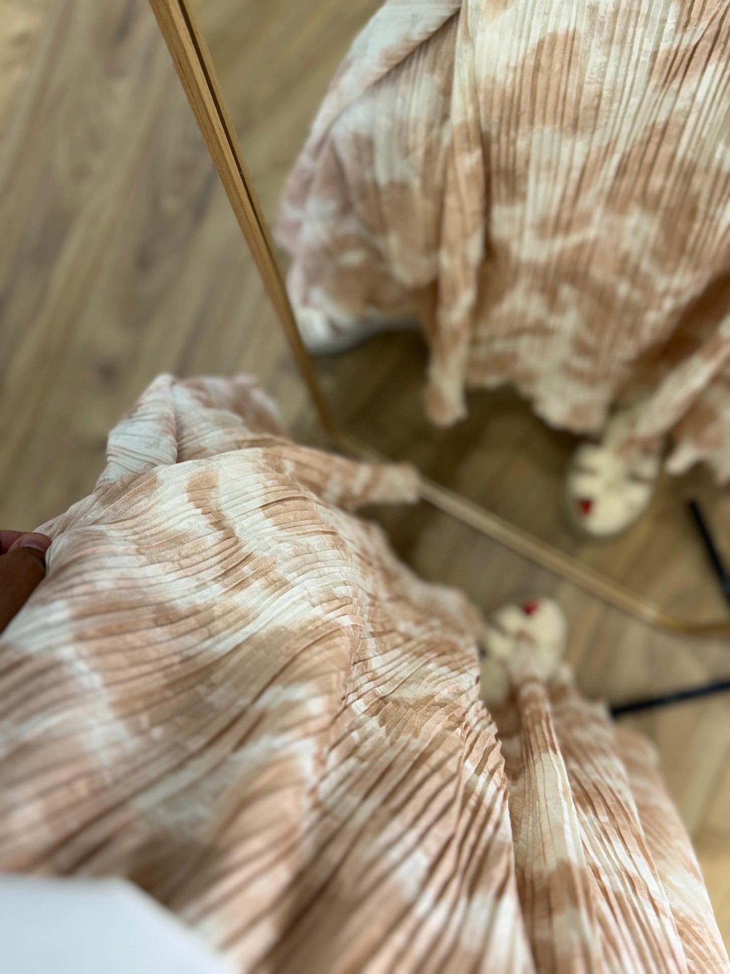 Détail du tissu plissé beige tie & dye, vue rapprochée.