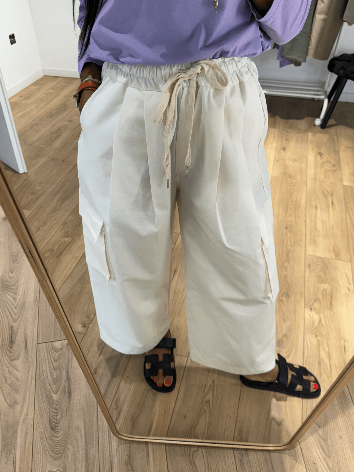 Zoom sur les détails du pantalon cargo femme en écru, montrant les poches avant et la ceinture.