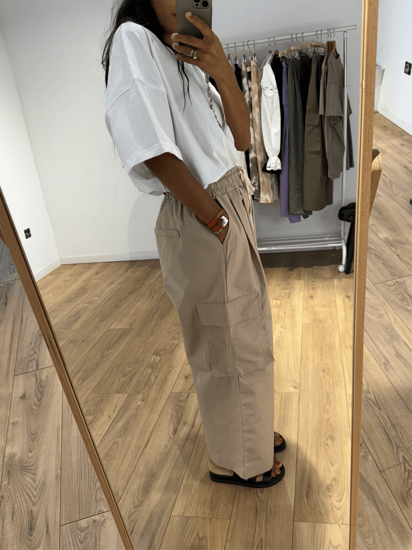 Vue de profil du pantalon cargo femme en taupe porté avec t-shirt blanc.